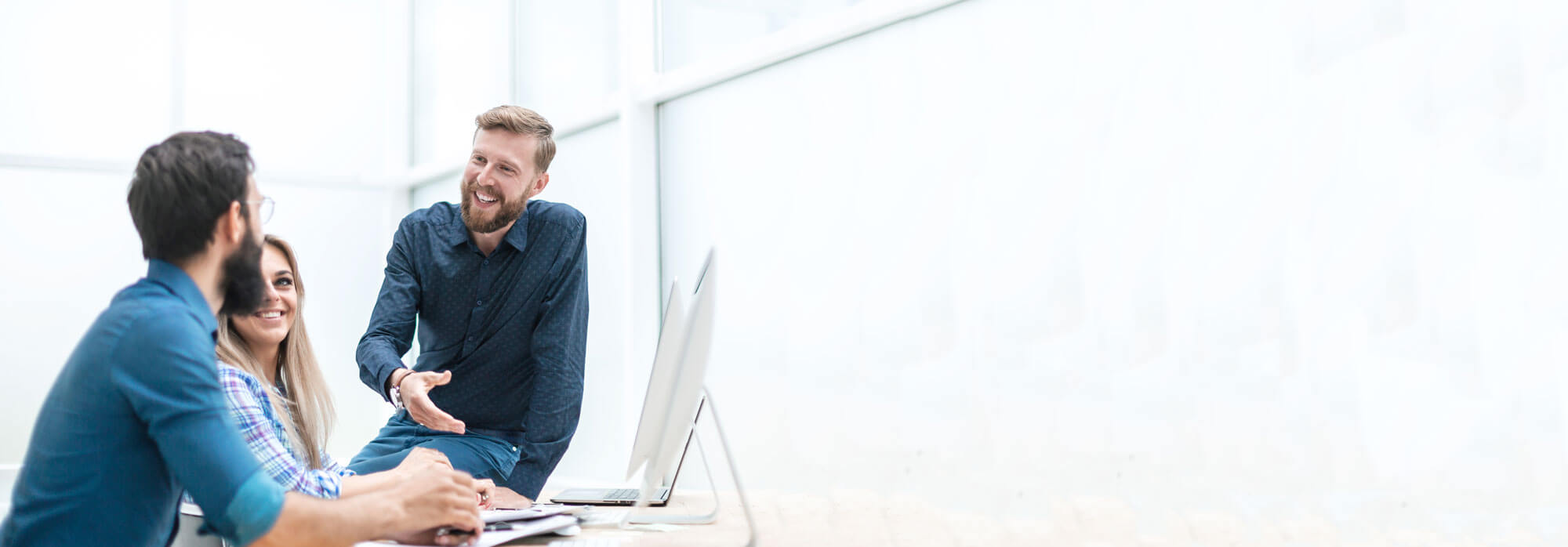 A man shows two people using a laptop an Arden website.